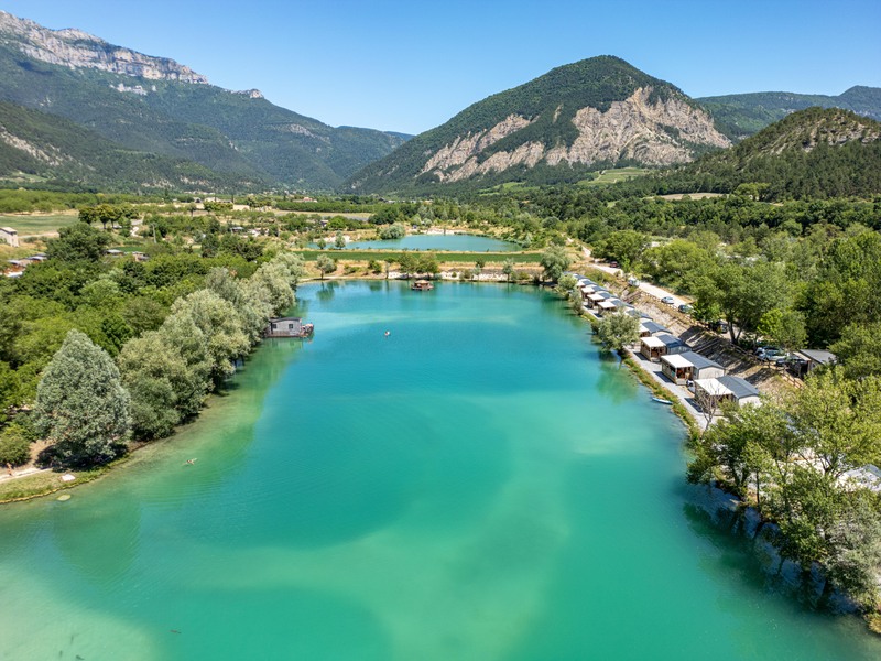 The lake at the heart of Campsite Le Lac Bleu in Châtillon-en-Diois in the Drôme, surrounded by monil-homes