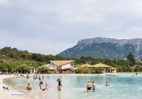 Baignade au lac de la Germanette à Serres avec vue sur les montagnes des Hautes-Alpes depuis le camping Les Princes d'Orange Ciela Village