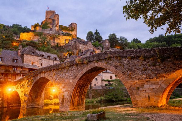 Vue panoramique sur le pont illuminé et château fort du village de Belcastel près Camping Le Caussanel - Ciela Village à Canet-de-Salars dans l'Aveyron