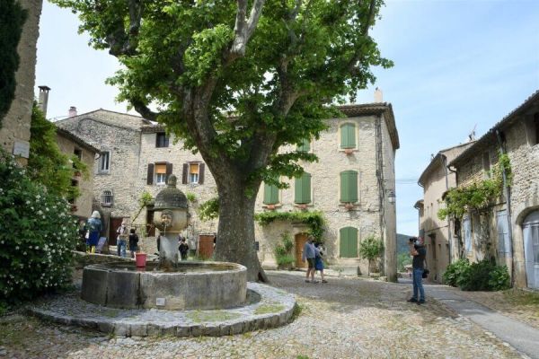Village avec fontaine à eau, ruelle pavée et maisons en pierre dans le village d'Alba-La-Romaine à proximité du camping Le Pommier - Ciela Village à Villeneuve de Berg en Ardèche