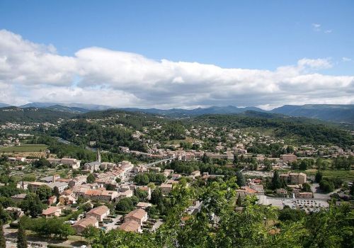 Vue aérienne du village d'Aubenas et montagnes ardéchoises sous un grand ciel bleu à proximité du camping Le Pommier - Ciela Village à Villeneuve de Berg en Ardèche