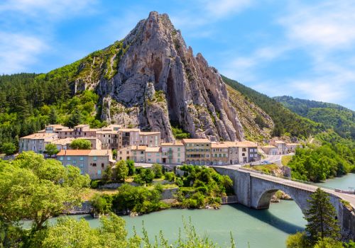 Vue panaramique sur le vieux village de Sisteron et son pont au bord de la Durance, dominés par l'impressionnant Rocher de la Baume près du Camping Les Princes d'Orange - Ciela Village à Orpierre dans les Hautes-Alpes