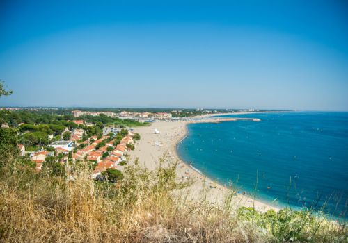 Vue panoramique depuis les hauteurs sur la plage de sable du Racou et ses maisons de bord de merà proximité du camping Les Marsouins - Ciela Village à Argelès-sur-Mer en Occitanie