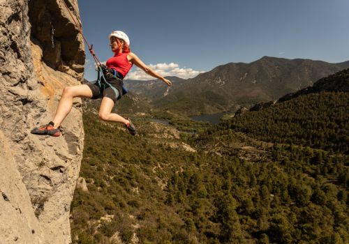 Femme qui fait de l'escalade sur les falaises d'Orpierre à proxmité du Camping Les Princes d'Orange - Ciela Village à Orpierre dans les Hautes-Alpes