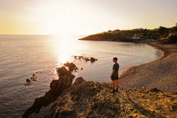 Un coureur qui admire le cocuher de soleil sur la mer sur le Sentier du Litroral à proximité du camping Les Marsouins - Ciela Village à Argelès-sur-Mer en Occitanie