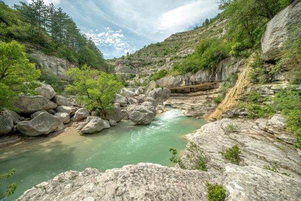 Paysage sauvage des Gorges de la Méouge avec ses vasques d'eau claire et ses falaises boisées sous un ciel voilé près du Camping Les Princes d'Orange - Ciela Village à Orpierre dans les Hautes-Alpes