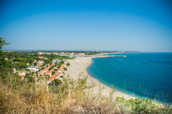 Vue panoramique depuis les hauteurs sur la plage de sable du Racou et ses maisons de bord de merà proximité du camping Les Marsouins - Ciela Village à Argelès-sur-Mer en Occitanie