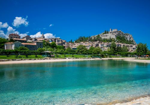 Le plan d'eau de baignade des Marres à Sisteron avec vue panoramique sur la citadelle historique près du Camping Les Princes d'Orange - Ciela Village à Orpierre dans les Hautes-Alpes