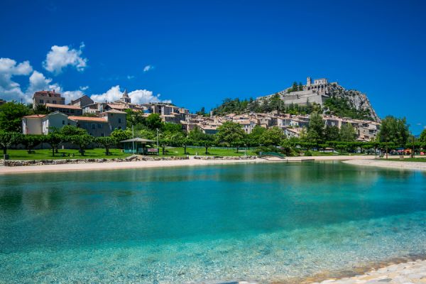 Le plan d'eau de baignade des Marres à Sisteron avec vue panoramique sur la citadelle historique près du Camping Les Princes d'Orange - Ciela Village à Orpierre dans les Hautes-Alpes