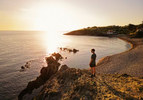 Un coureur qui admire le cocuher de soleil sur la mer sur le Sentier du Litroral à proximité du camping Les Marsouins - Ciela Village à Argelès-sur-Mer en Occitanie